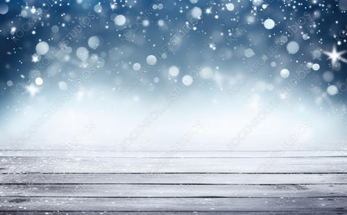 Beautiful winter snowy blurred defocused blue background and empty wooden flooring. Flakes of snow fall and sparkle on light, copy space.