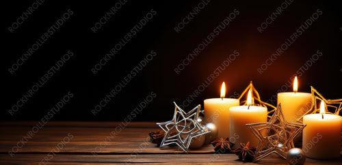 Merry Christmas and happy New Year. A warm dark golden brown wooden background with burning candles and a Christmas star. Elegant low-key shot with festive mood. Template for the congratulatory text.