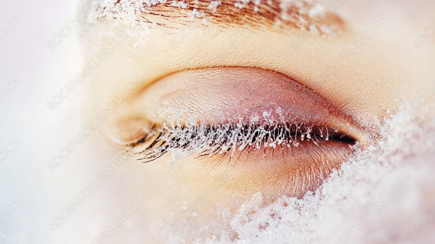 Close-up of Frost-Covered Closed Eye in Winter Freeze with Snowflakes on Eyelashes