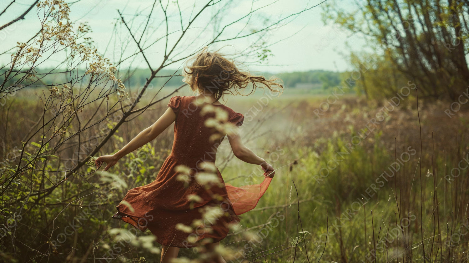 Joyful Girl Dancing in a Field of Tall Grass on a Breezy Day