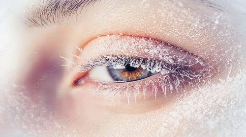 Close-up of Frost-Covered Closed Eye in Winter Freeze with Snowflakes on Eyelashes