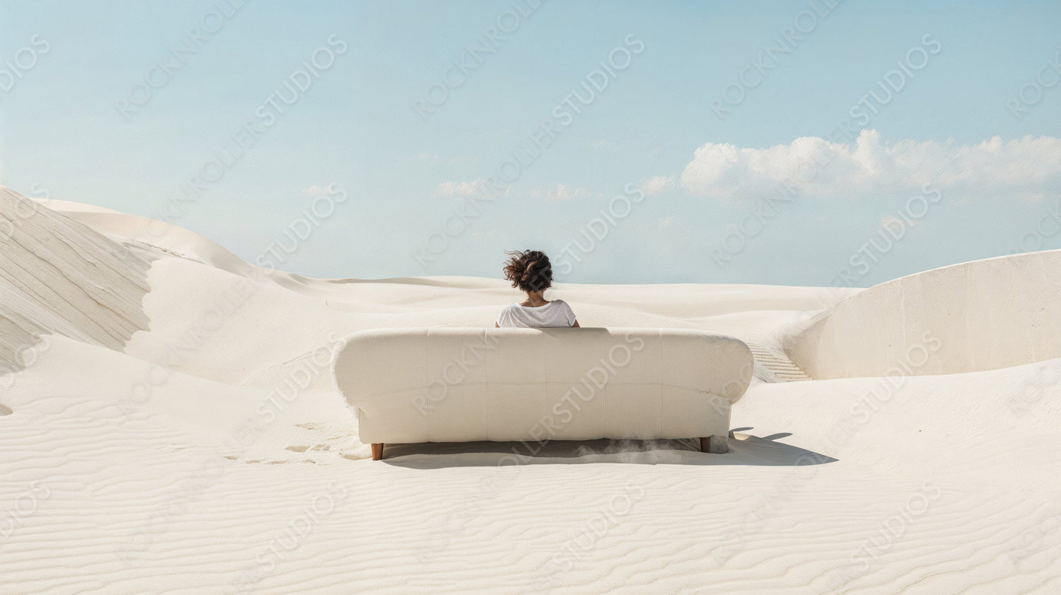 Solitary Figure on a White Couch in a Vast Desert Landscape