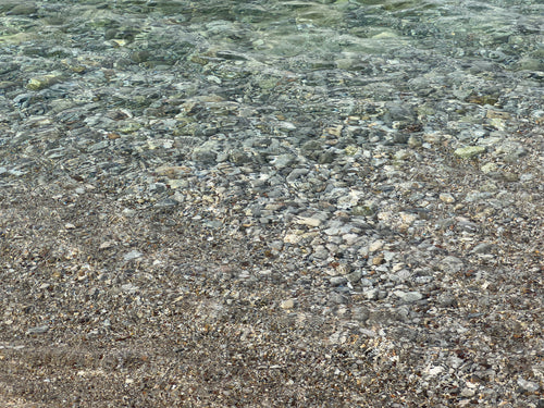 Pebbles Under Clear Water, Serene Rocky Shoreline