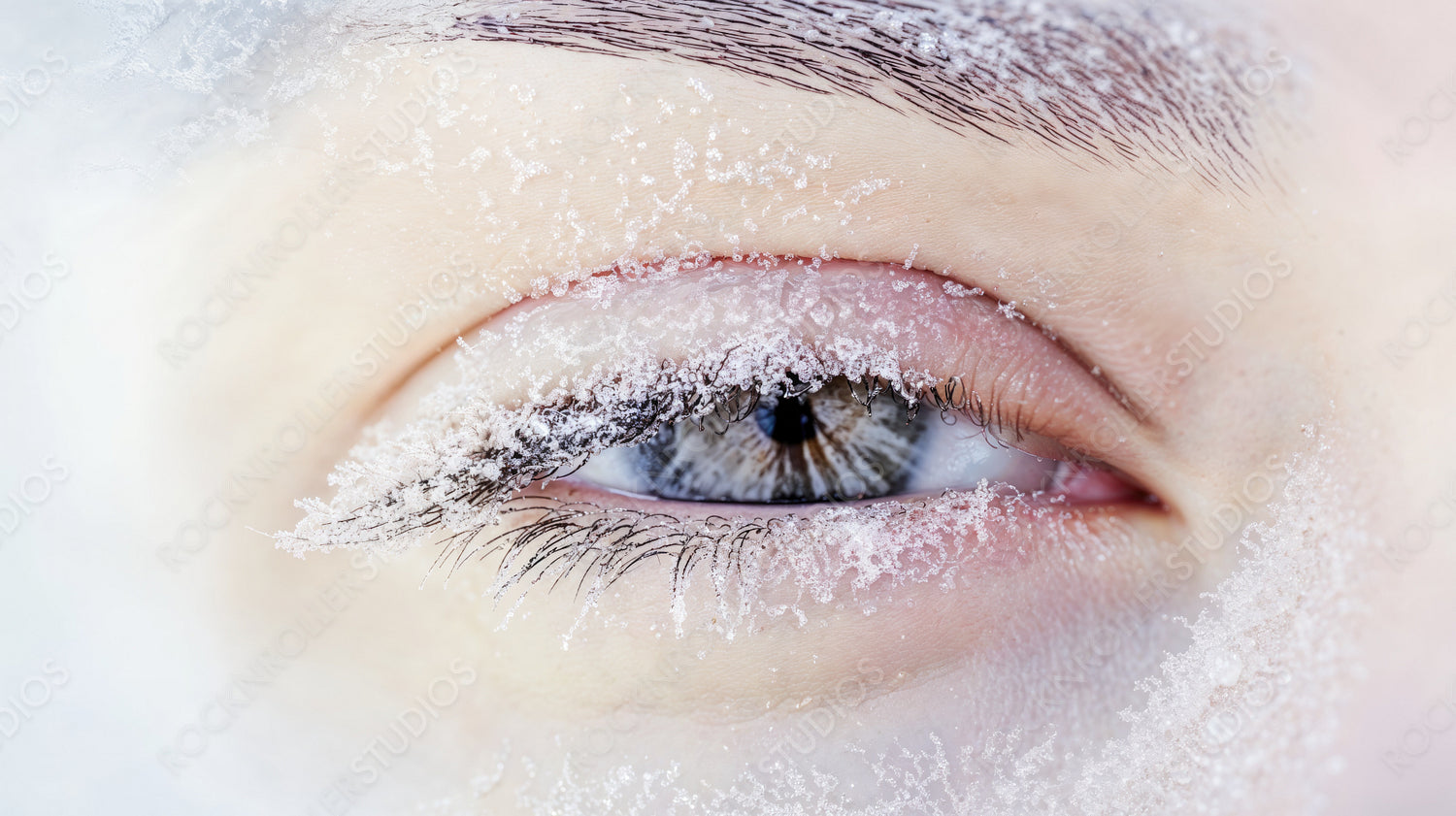 Close-up of Frost-Covered Closed Eye in Winter Freeze with Snowflakes on Eyelashes