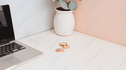 Office Desk with Laptop, Alarm Clock, and Coins - Modern Workspace and Finance Concept