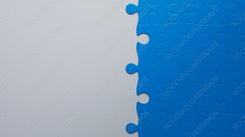 Strategic Minds at Work: Incomplete Blue Jigsaw Puzzle on Grey, Symbolizing Teamwork and Problem-Solving