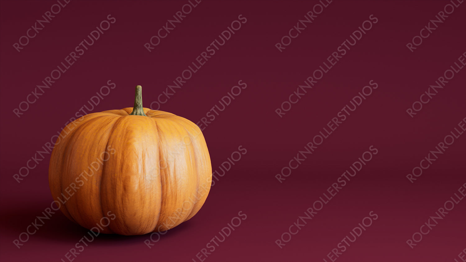 Pumpkin on a Burgundy colored background. Fall themed Image with copy-space.